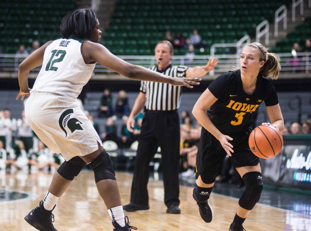 <p>Sophomore forward Nia Hollie (12) fights for the ball against Iowa's sophomore forward Makenzie Meyer (3) in the game against Iowa on Feb. 1, 2018, at the Breslin Center. The Spartans fell to the Hawkeyes, 71-68 in overtime. (State News | Annie Barker)&nbsp;</p>