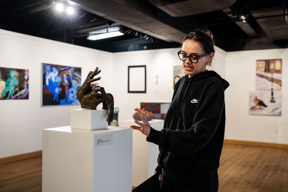 Fourth-year Michigan State studio art student Evan Yalowitz explains her piece Obstruction on the Rise on April 13, 2025. She said, “This piece was born out of mistakes and mess-ups, and this is the piece that truly allowed me to not be such a perfectionist.” She adds, “I had a very particular vision in mind of my hand being casted a certain way. However, each time I casted my hand, it didn’t turn out exactly how I wanted it to. So — three hands later — I just melted them all together.” 