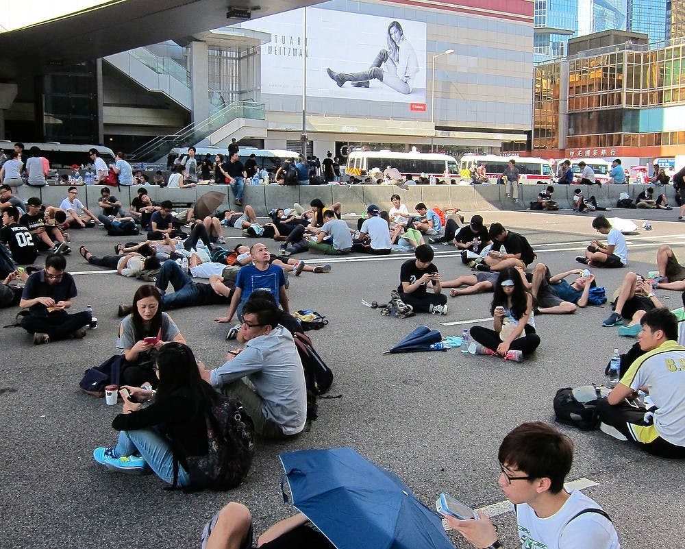 <p>Demonstrators rest near Hong Kong's government complex and in front of a fashion billboard on Monday after three days of protests and clashes with police. Many young people in Hong Kong complain that the city's economy it too geared toward tourism and high-end retail, leaving them with few job prospects. (Stuart Leavenworth/MCT)</p>