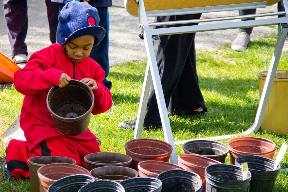 Marcelo Lawson, 6, of East Lansing pulls apart pots and sets them in lines to be filled up with dirt Sunday afternoon at Fenner Nature Center. Earth Day Extravaganza was put on with the help of Fenner Nature Center, the FW Graduate Student Organization, and several other MSU student groups. Aaron Snyder/The State News. 