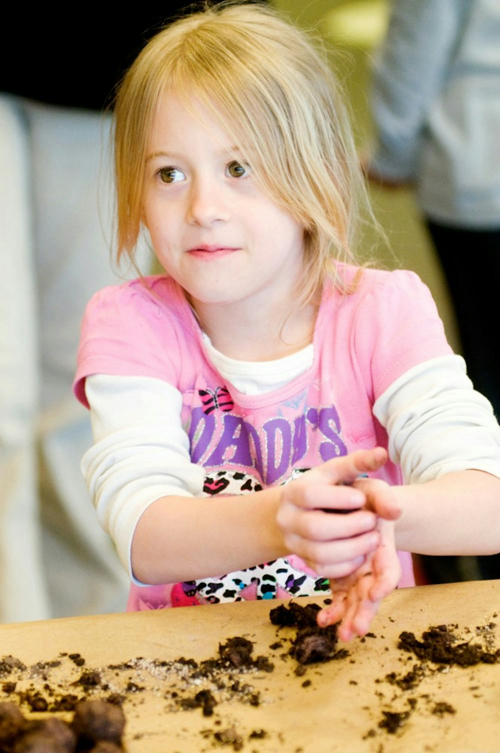 Lansing resident Lucie Simkins, 6, makes a seed bomb Saturday at The Land Grant held in the previous Barnes and Noble location on Grand River Ave. Various farming and sustainability activities were available for children of all ages.  Jaclyn McNeal/The State News