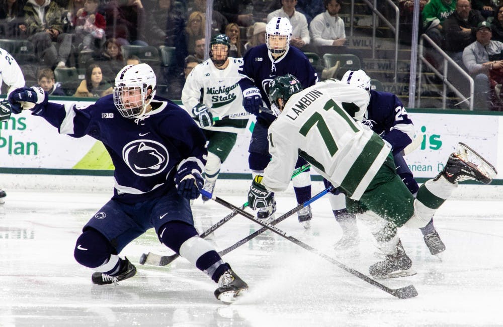 Junior wing Logan Lambdin (71) splits defenders during the game against Penn State on Feb.16, 2019. The Spartans fell to the Nittany Lions 5-3.