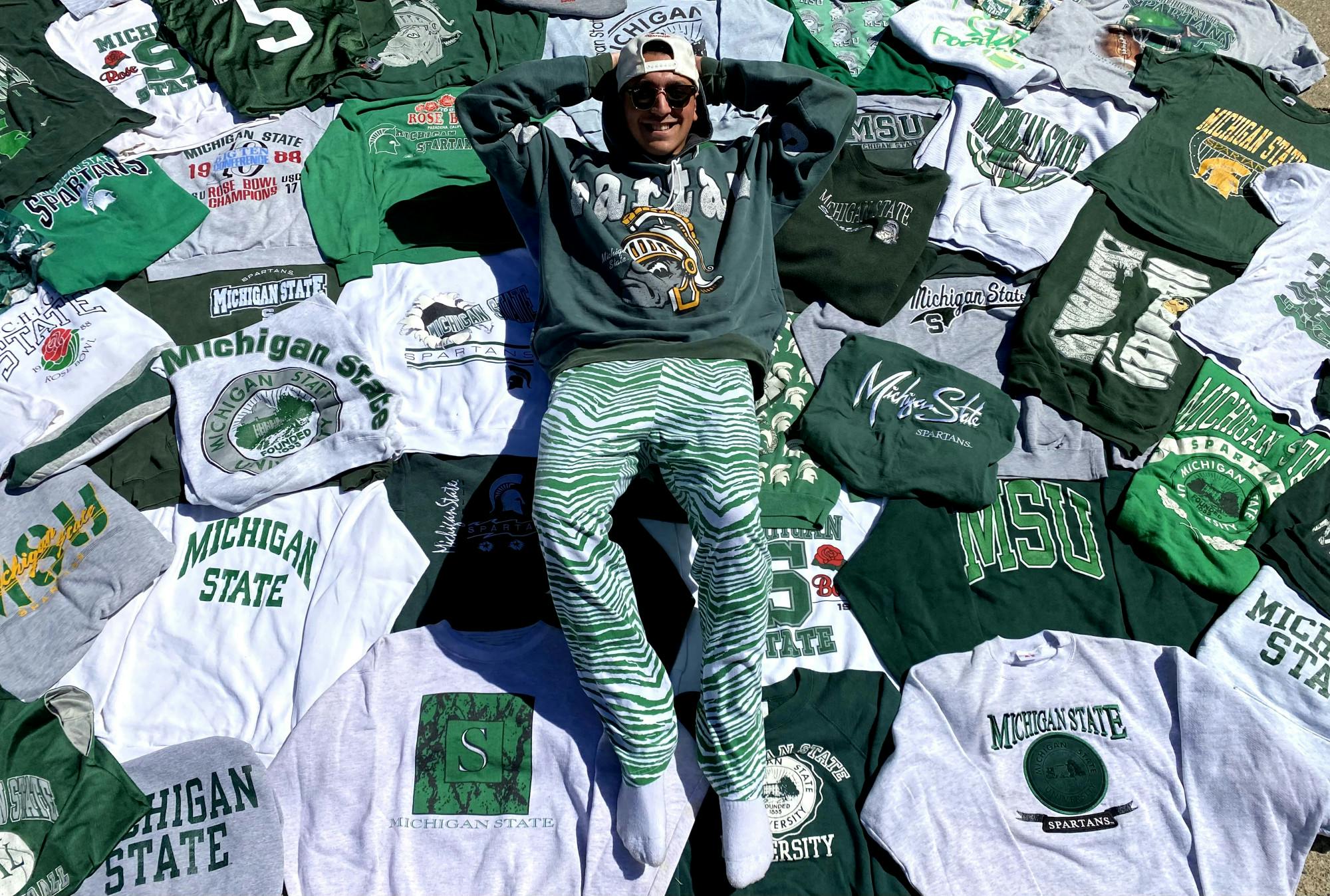 <p>Senior advertising management Jared Perlin lays in an assortment of his thrifted MSU vintage clothing that he&#x27;s collected over the years.</p>