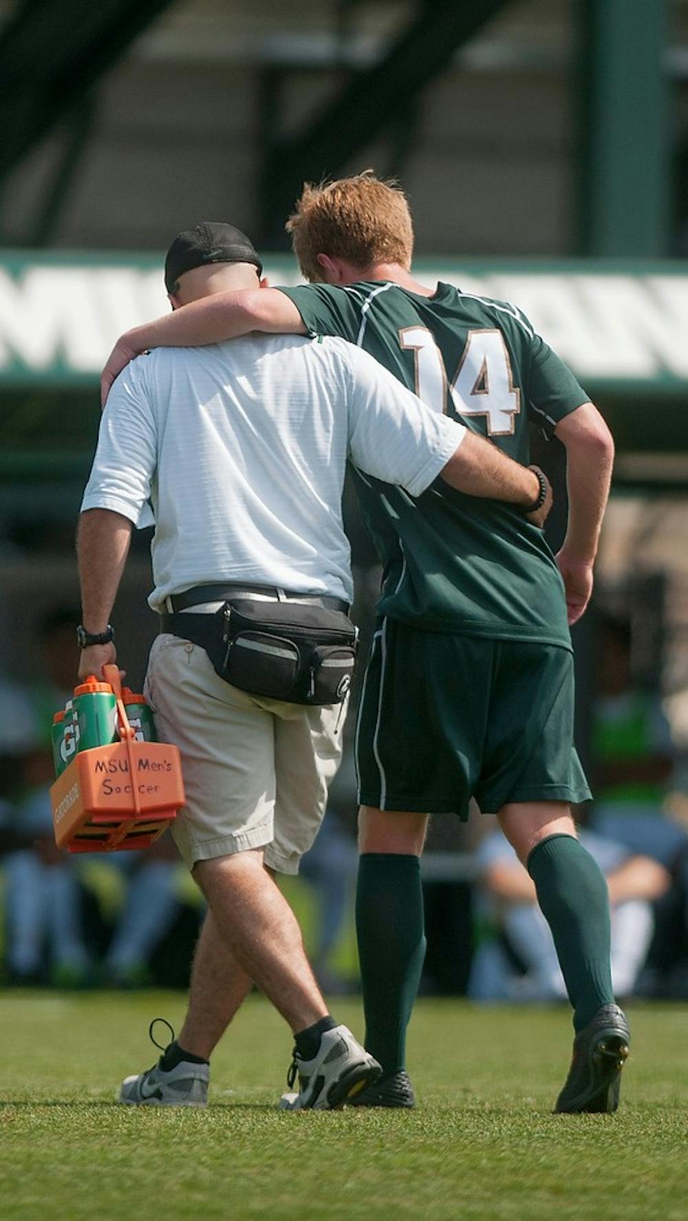 	<p>Freshman midfielder Dewey Lewis gets escorted off the field after injuring himself during the game on Sept. 8, 2013, at DeMartin Stadium at Old College Field. The Spartans lost to the Crusaders 1-2. Georgina De Moya/The State News</p>