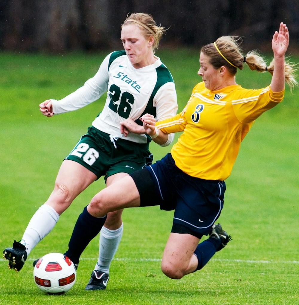 Sophomore defender Desiree Aber dribbles up field as Toledo midfielder Blair Sorg attempts to steal the ball with a slide tackle Saturday afternoon at DeMartin Stadium at Old College Field. The Spartans tied Toledo in the exhibition match 1-1. Matt Hallowell/The State News
