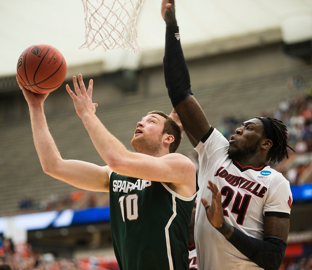 <p>Then-junior forward Matt Costello attempts a basket over Louisville forward Montrezl Harrell March 28, 2015, during the East Regional round of the NCAA Tournament in the Elite Eight against Louisville at the Carrier Dome in Syracuse, New York. The Spartans defeated the Cardinals in overtime, 76-70. Erin Hampton/The State News</p>