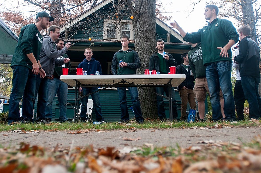 <p>Students and alumni tailgate before the game against Michigan on Oct. 25, 2014, at a house on Ann Street in East Lansing. Julia Nagy/The State News</p>