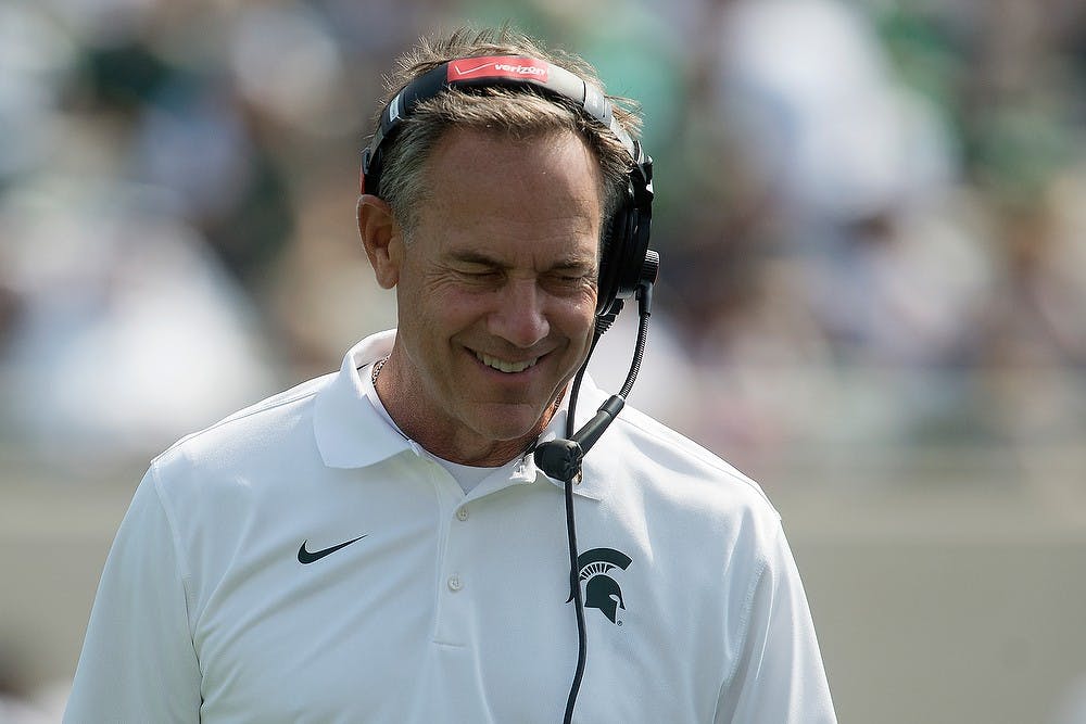 <p>Head Coach Mark Dantonio smiles during a timeout during the game against Eastern Michigan on Sept. 20, 2014, at Spartan Stadium. The Spartans defeated the Eagles, 73-14. Julia Nagy/The State News</p>