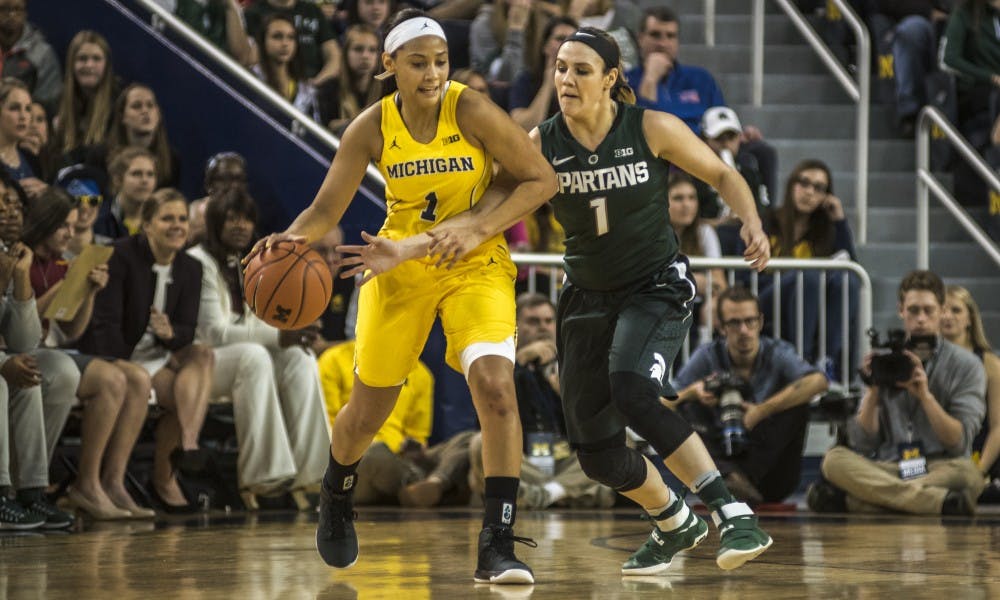Senior guard Tori Jankoska (1) attempts to take the ball from Michigan guard Kysre Gondrezick (1) during the women's basketball game against the University of Michigan on Feb. 19, 2017 at Crisler Arena in Ann Arbor, Mich. The Spartans defeated the Wolverines, 86-68.