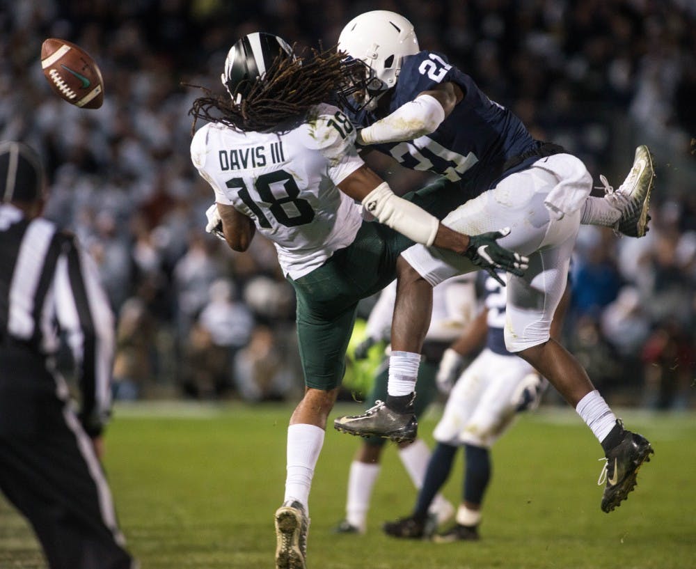Penn State center back Amani Oruwariye (21) tackles senior wide receiver Felton Davis III (18) during the game against Penn State at Beaver Stadium on Oct. 13, 2018. The Spartans defeated the Nittany Lions 21-17.