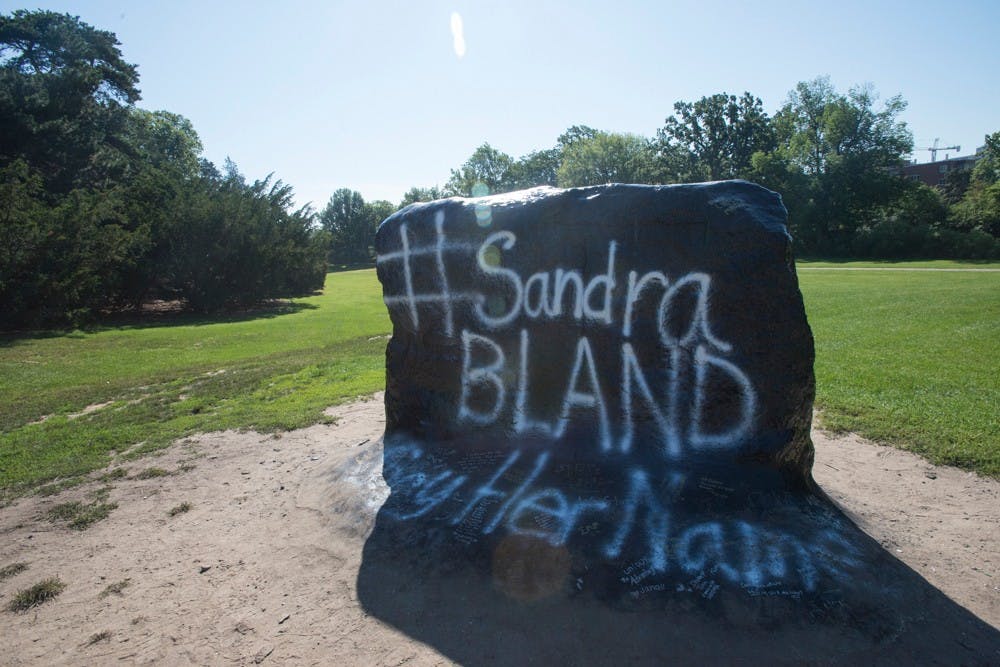 <p>Students write notes to Sandra and poems expressing their frustration with her death on the rock. Catherine Ferland/ The State News</p>