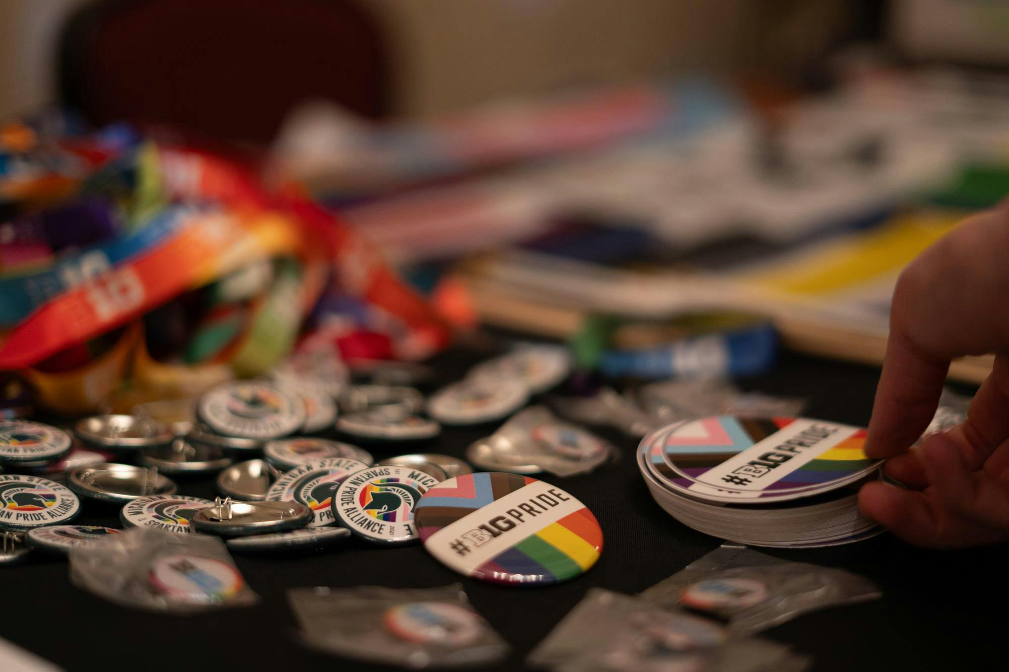 The Spartan Pride Alliance table provides "#B1G Pride" stickers, lanyards, and pins. The Pride Showcase took place in the MSU Union Ballroom on April 3, 2024.