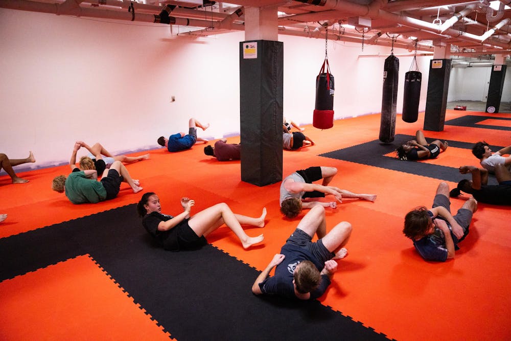 MSU MMA Club members perform a shrimping exercise as part of a warmup before practice in Room 16 of IM West on Oct. 6, 2024. Shrimping is an exercise that involves moving the hips, legs and shoulders in order to increase ground mobility.