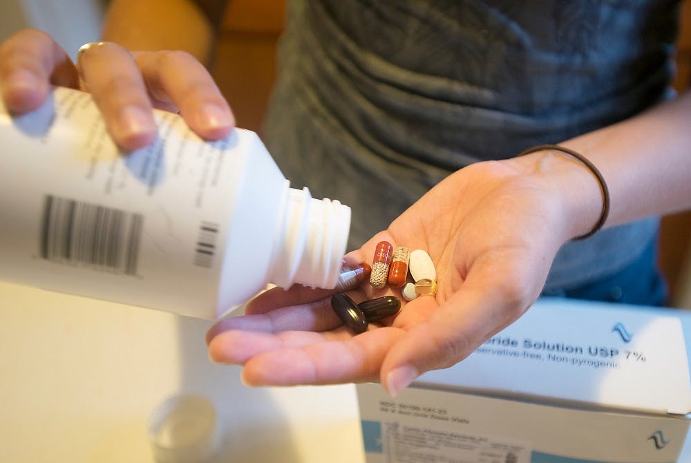 	<p>Special education senior Julia Ruggirello takes her medication for her cystic fibrosis Sept. 10, 2013, at her home on Stoddard Avenue. Ruggirello said she often jokes about getting packages with her medication, because of how expensive they are. &#8220;I just got a $15,000 package,&#8221; Ruggirello said. Julia Nagy/The State News</p>