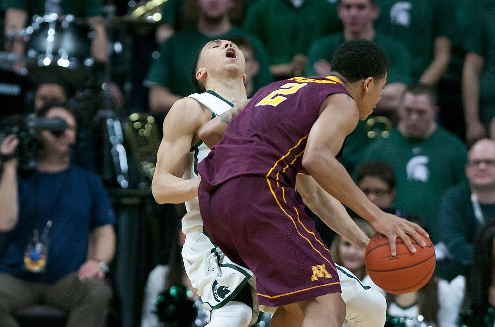 <p>Senior guard Travis Trice is fouled by Minnesota guard Nate Mason Feb 26, 2015, during the game against Minnesota at Breslin Center. The Spartans fell to the Golden Gophers in overtime, 96-90. Kennedy Thatch/The State News</p>