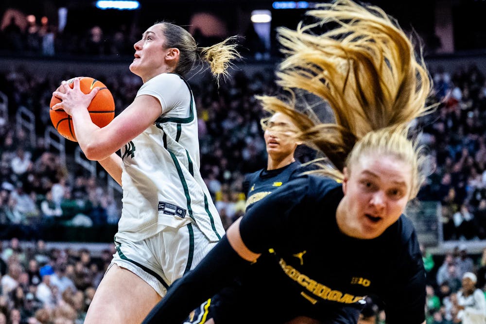 Michigan State Spartans Grace VanSlooten (48) drives the ball towards the hoop as Michigan Wolverines guard Brooke Q. Daniels (5) falls during the women’s rivalry matchup at the Breslin Student Events Center in East Lansing, Mich., on Sunday, Feb. 1, 2026.