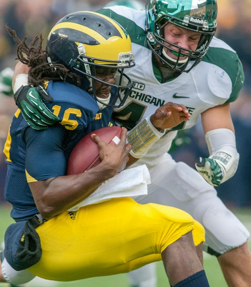 	<p>Junior linebacker Max Bullough tackles Michigan quarterback Denard Robinson in the first half. Michigan defeated Michigan State, 12-10, on Saturday afternoon, Oct. 20, 2012, at Michigan Stadium in Ann Arbor, Mich. Justin Wan/The State News</p>