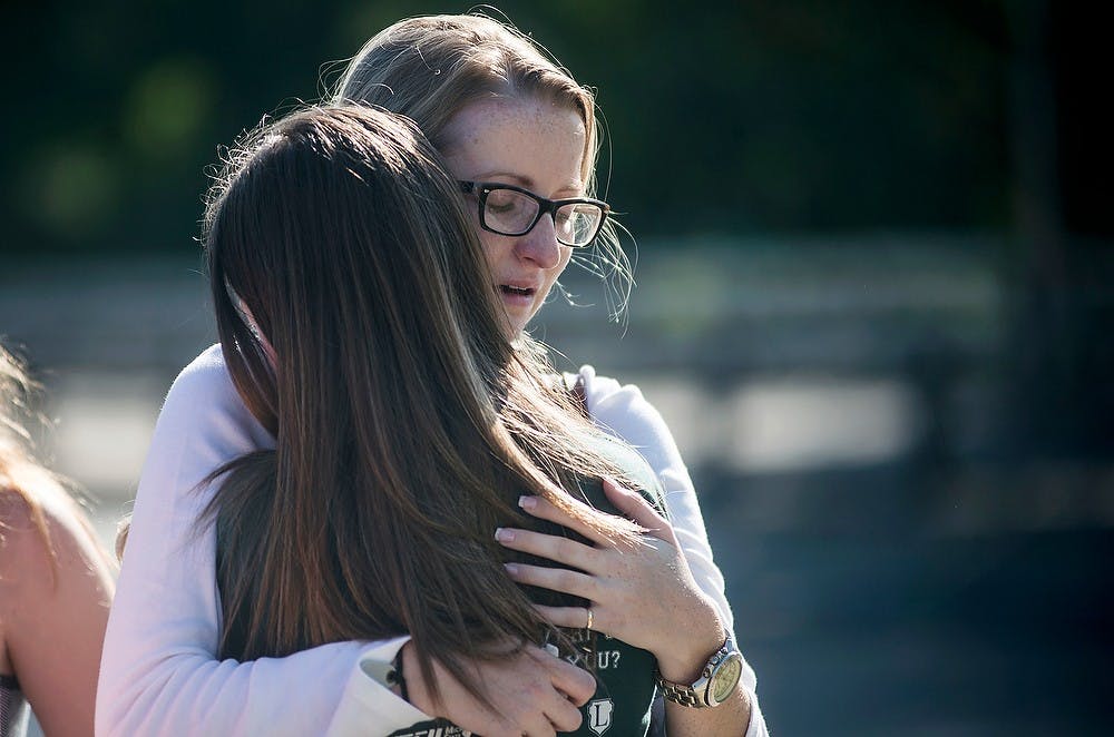 <p>Dietetics senior Hannah Byrne, right, hugs hospitality business junior Ashley Day on Sept. 28, 2014, during accounting senior Morgan McGregor's memorial at the Rock on Farm Lane. McGregor was pacemaker dependent. Erin Hampton/The State News</p>