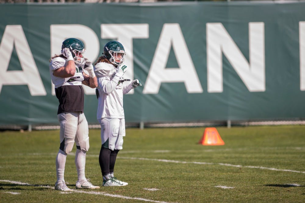 Senior linebacker Riley Bullough, left, and junior linebacker Chris Frey wait before a drill begins on April 5, 2016 at the practice fields behind the Duffy Daugherty Football Building.