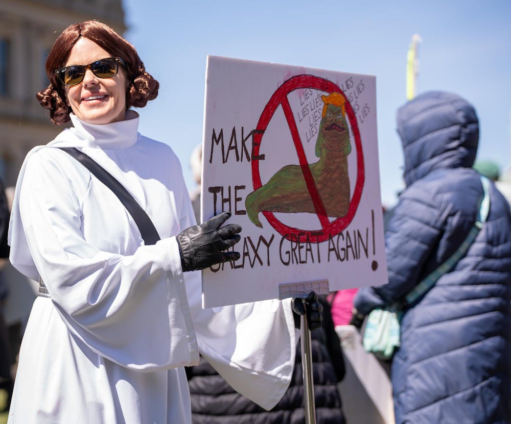 <p>A protestor holds up a sign during the No Kings Protest at the Michigan State Capitol in Lansing, MI on March 28, 2026.</p>