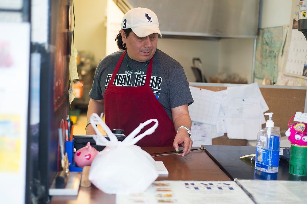 <p>Owner and Lansing resident Jose Miroquesada packages an order to-go April 9, 2015, at Jose's Cuban Sandwich & Deli on E. Grand River Avenue in Lansing. Jose's provides authentic Cuban sandwiches and Cuban deli. Hannah Levy/The State News</p>