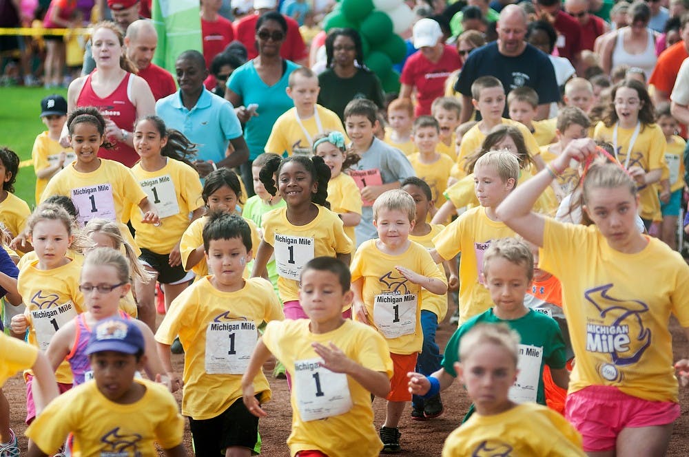 	<p>Kids run from the starting line at the beginning of the Sparrow Michigan Mile on June 1, 2013, at Cooley Law School Stadium in Lansing. Kids under the age of 13 participated in the mile run in order to promote healthy living. Danyelle Morrow/The State News</p>