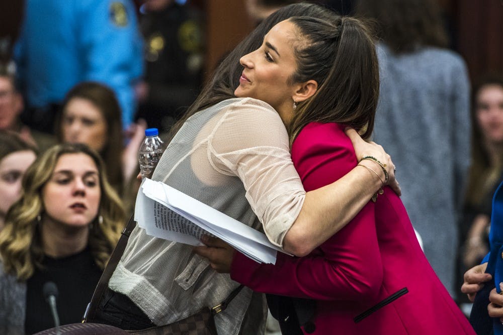 Six-time Olympic medal winner Aly Raisman, right, hugs Olympic gold medalist and gymnast Jordan Wieber after giving a statement to Ex-MSU and USA Gymnastics Dr. Larry Nassar on the fourth day of Nassar's sentencing on Jan. 19, 2018 at the Ingham County Circuit Court in Lansing. (Nic Antaya | The State News)
