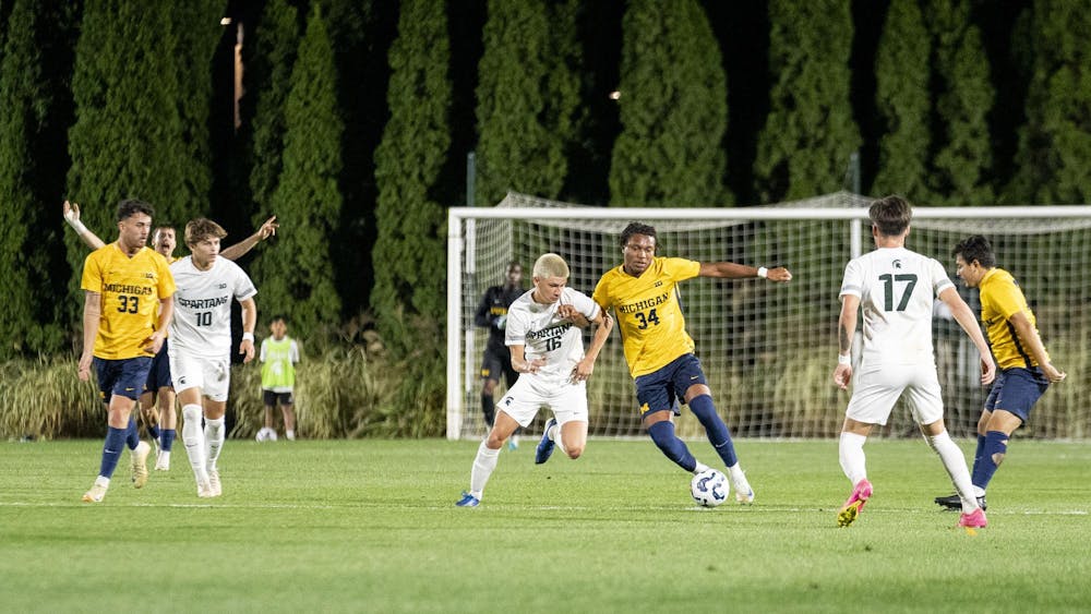 <p>Michigan State University sophomore midfielder Colin Arce (16) and University of Michigan freshman midfielder Kamau Brame (34) run after the ball during the MSU vs. UOM men’s soccer match at DeMartin Stadium on Oct. 22, 2024.</p>