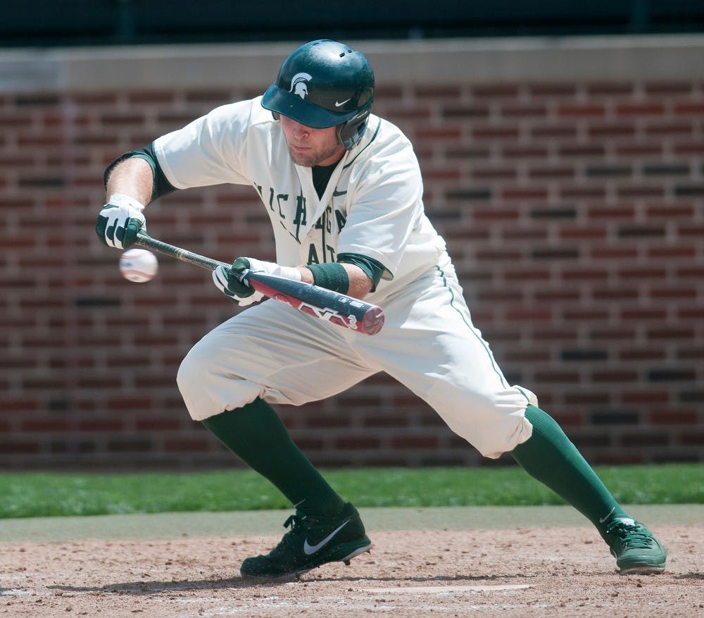 <p>Then-sophomore right fielder Jimmy Pickens bunts the ball in the third game of the series against the University of Illinois on May 5, 2013, at McLane Baseball Stadium at Old College Field. Pickens is leading MSU into a tough stretch of games this week. Danyelle Morrow/The State News</p>