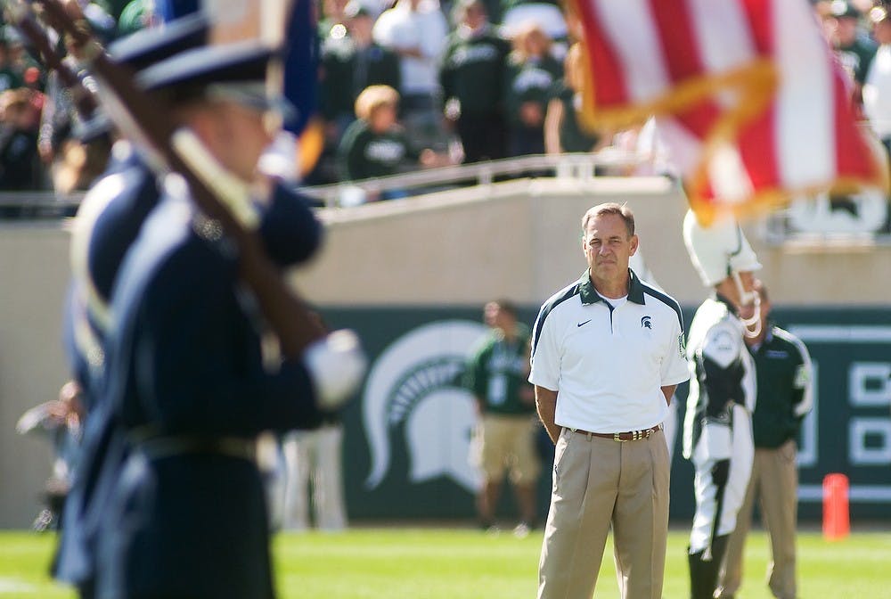 <p>Head coach Mark Dantonio stands as Air Force members hold the flag during the playing of the National Anthem before Saturday's game against Central Michigan at Spartan Stadium. Lauren Wood/The State News</p>