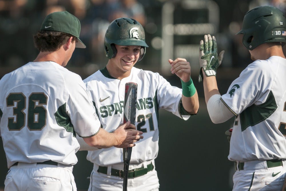 <p>Redshirt-sophomore outfielder Dan Chmielewski (21) high-fives teammates during the game against Toledo on April 26, 2017 at McLane Baseball Stadium at Kobs field. The Spartans defeated the Titans, 11-1.&nbsp;</p>