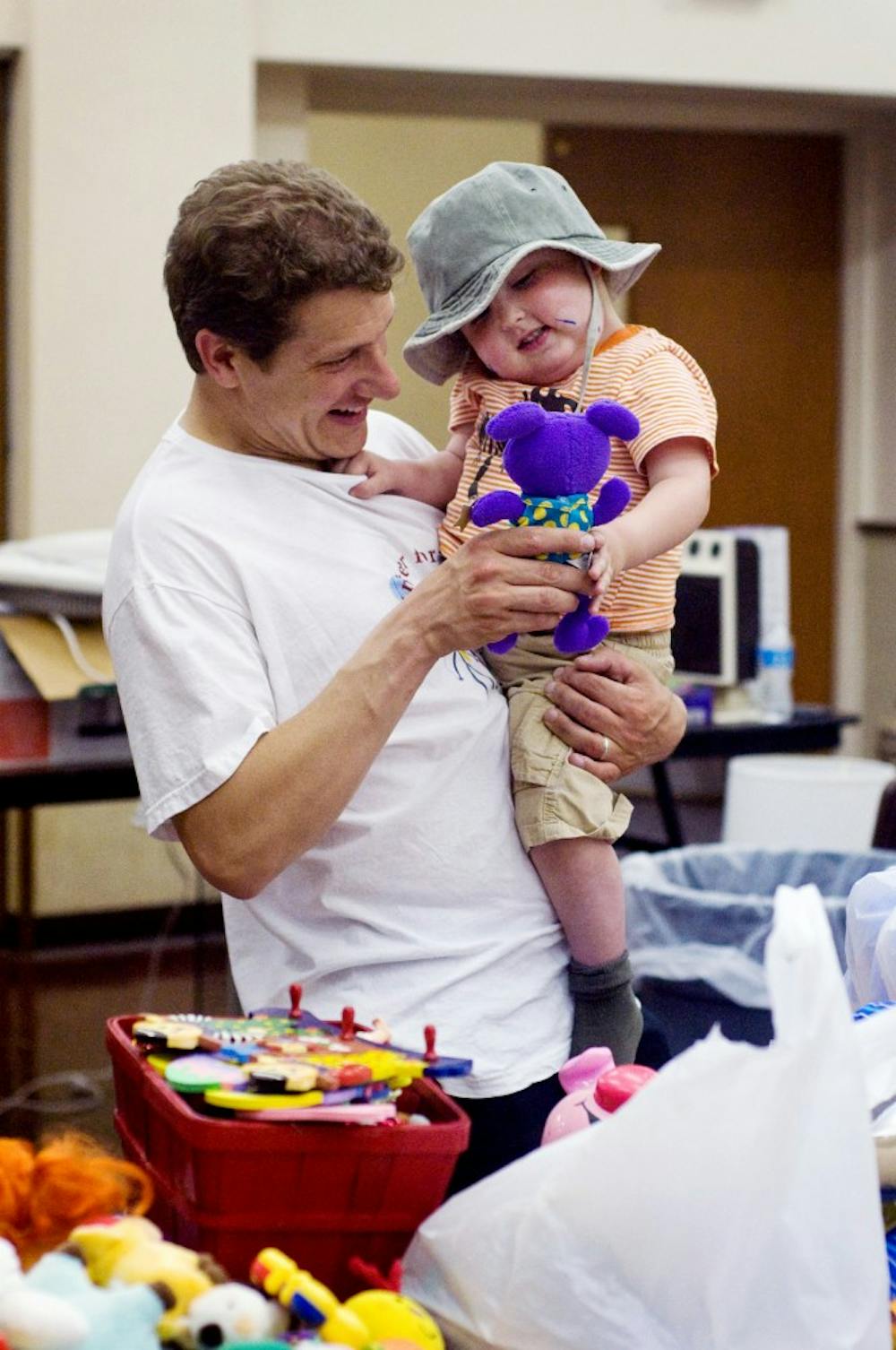 	<p>John Waller, a Lyman Briggs associate professor, left, looks at toys with his son, Charlie, 2, Thursday at The People&#8217;s Church, 200 W. Grand River. Toys and other items currently are  being collected at the church for a rummage sale to be held Saturday benefiting Charlie, who was diagnosed with a rare form of brain cancer in April.</p>
