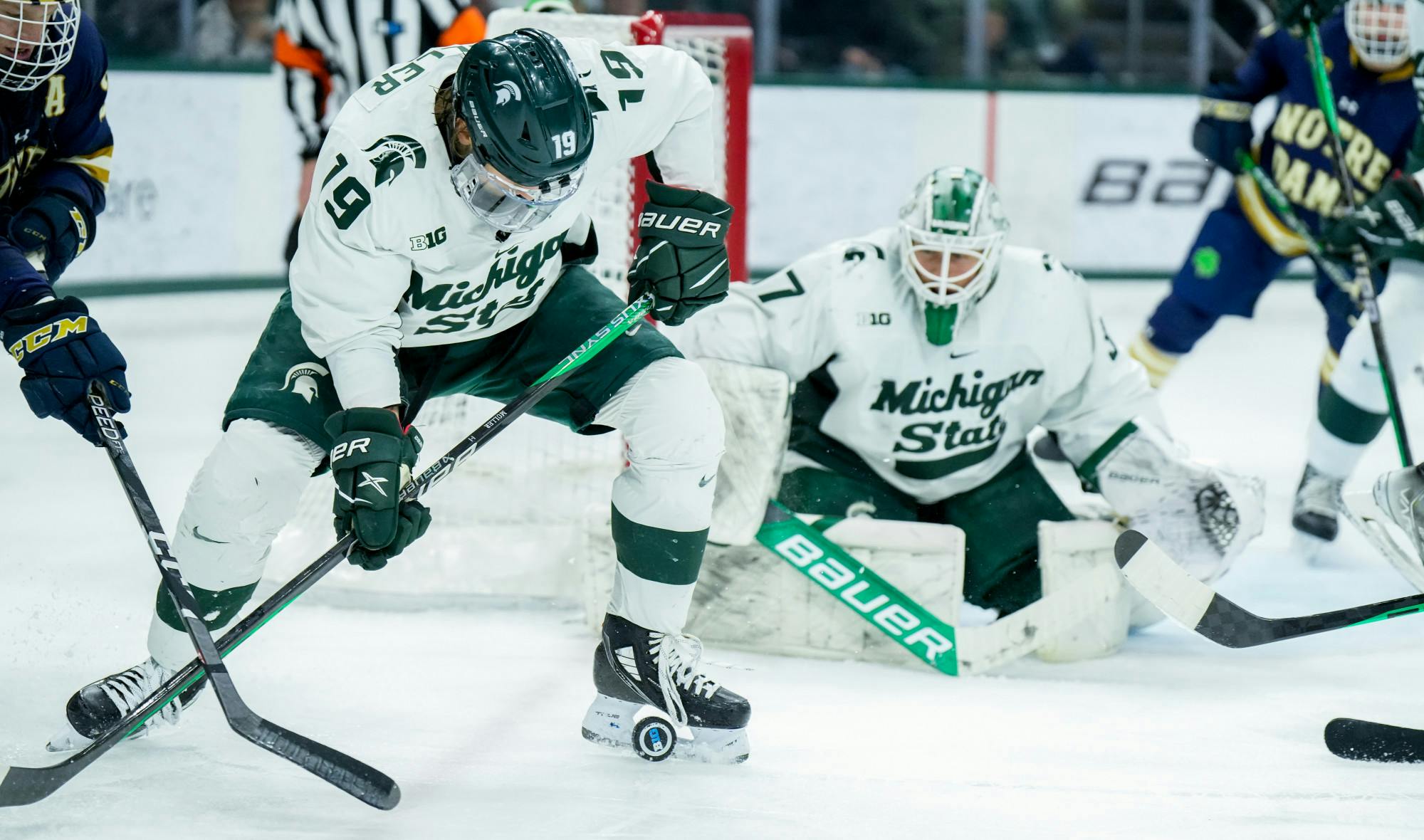 <p>Senior forward Nicolas Müller (19) is about to pass the puck during a game against Notre Dame at Munn Ice Arena on Feb. 3, 2023. The Spartans defeated the Fighting Irish 3-0.</p>