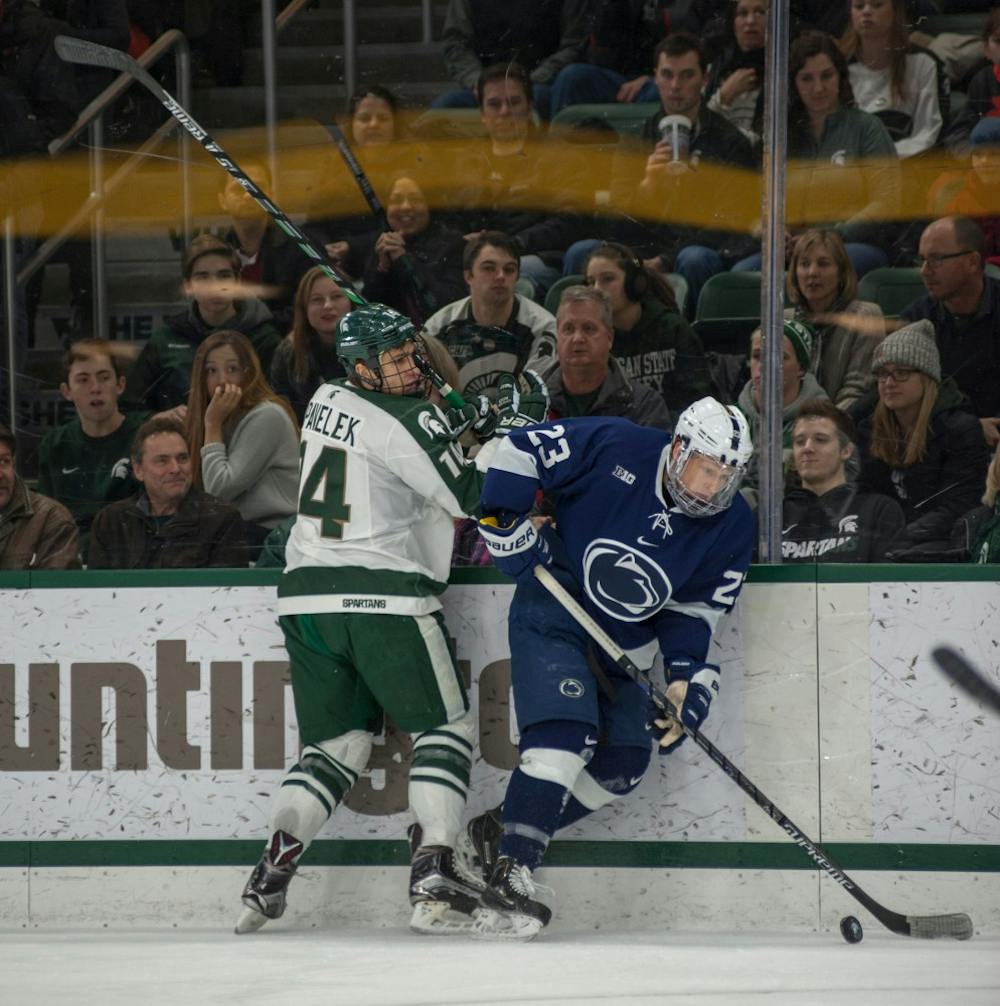 Penn state forward Eric Scheid fights for the puck as sophomore forward Dylan Pavelek defends him during the hockey game against Penn State on Feb. 13, 2016 at Munn Ice Arena. The Spartans were defeated in shootout by the Nittany Lion, 2-2.