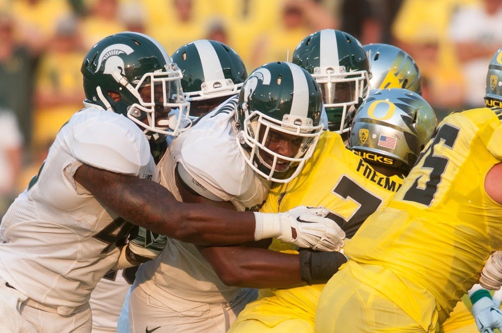 <p>Junior defensive end Shilique Calhoun tackles Oregon running back Royce Freeman on Sept. 6, 2014, at Autzen Stadium in Eugene, Ore. The Spartans lost to the Ducks, 46-27. Julia Nagy/The State News</p>