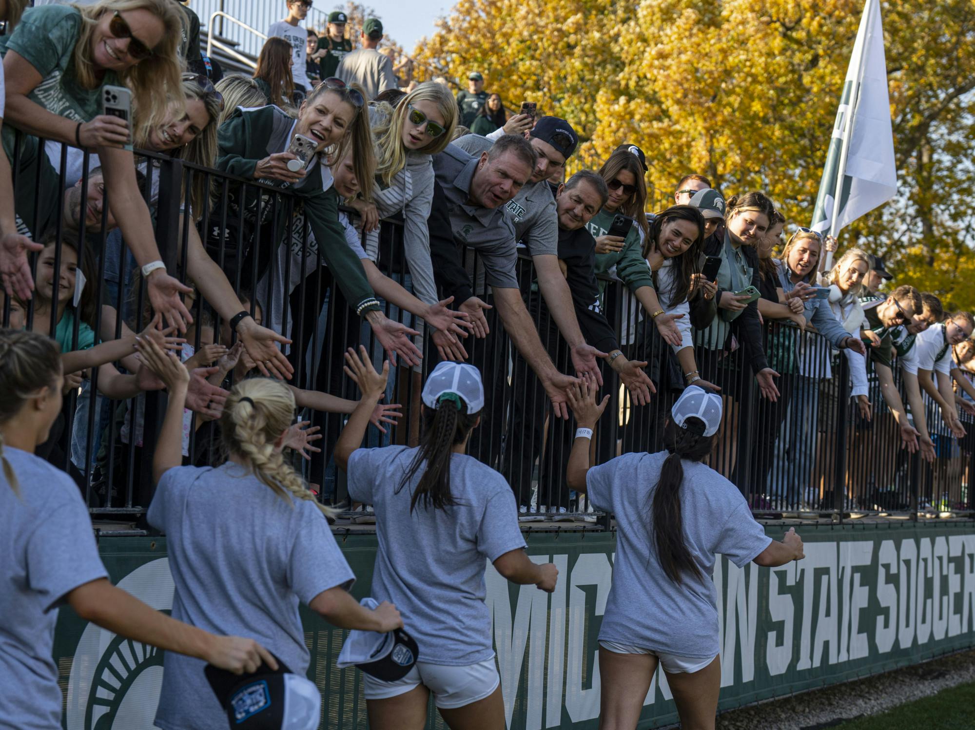 Fans reach for high-fives from the team after Michigan State’s win over the Rutgers, 1-0, on Sunday, Oct. 23, 2022 at DeMartin Stadium. The Spartans also celebrated their B1G Championship.