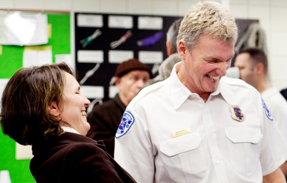 East Lansing fire marshal Bob Pratt jokes with friend Angela Michael during his retirement party thursday morning at East Lansing Fire Department Station 1. Pratt is retiring after giving 25 years of service. Samantha Radecki/The State News