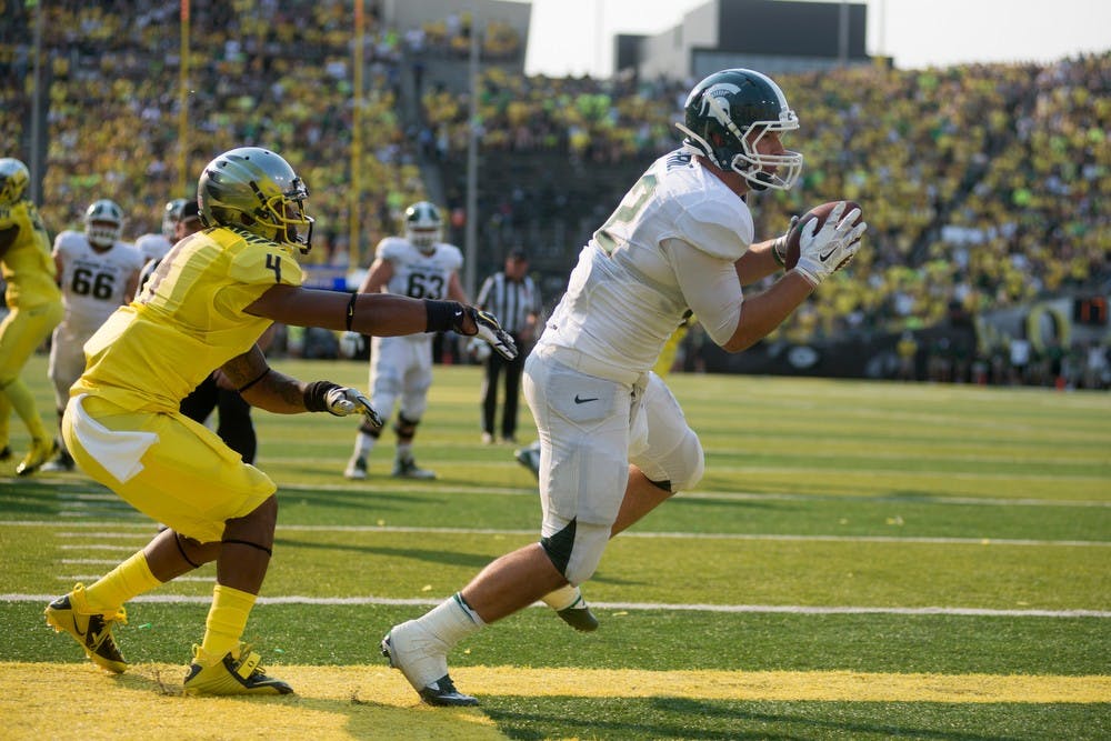 <p>Sophomore tight end Josiah Price scores a touchdown, propelling the Spartans to a lead going into the second half, during the game against Oregon on Sept. 6, 2014, at Autzen Stadium in Eugene, Ore. The Spartans lost to the Ducks, 46-27. Julia Nagy/The State News</p>