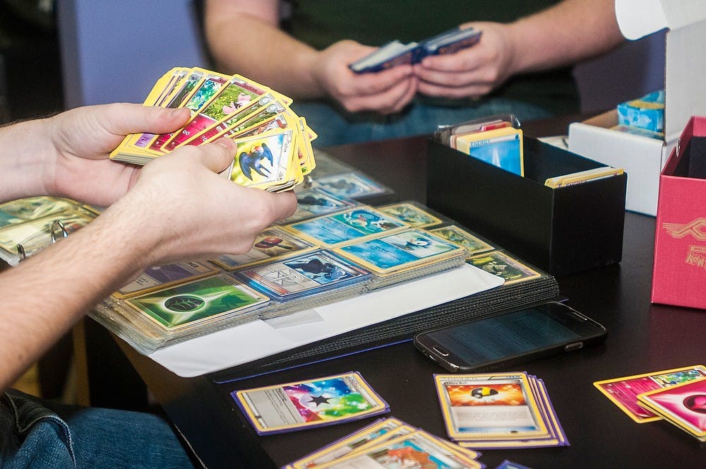 	<p>Computer science sophomore Alex Hill goes through a deck of Pokémon cards before a tournament Feb. 5, 2014, at Hollow Mountain Comics, 611 East Grand River Ave.  Hill is a part of a Pokémon club consisting of 15-20 members. </p>