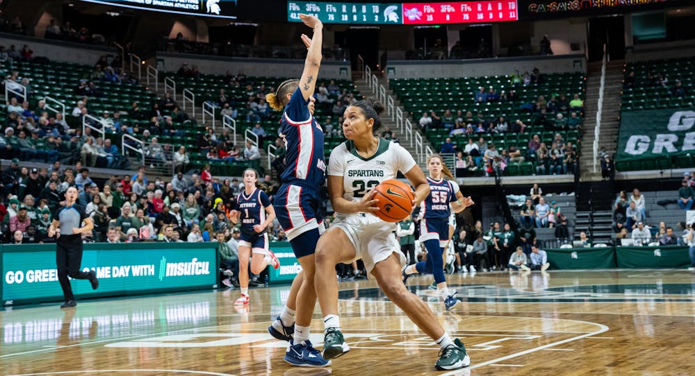 Detroit Mercy's Myinna Hooper (4) attempts to block a shot attempt by Michigan State's Moira Joiner (22). The Spartans defeated Detroit Mercy 91-41 in the Breslin Student Events Center on Dec. 18, 2022.