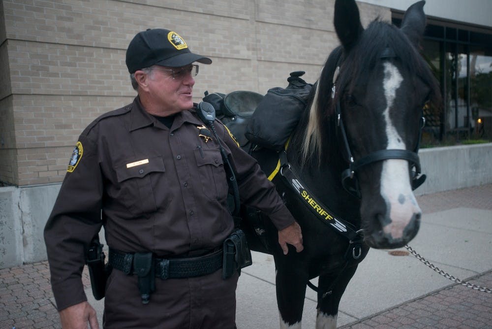 <p>Ingham County Sheriff Deputy Steve Law and his horse, Jazz, await departure Sept. 11, 2015 outside of the East Lansing Police Department on 409 Park Lane. Law said he "hopes this weekend is safe, fun and successful". Alice Kole/The State News</p>