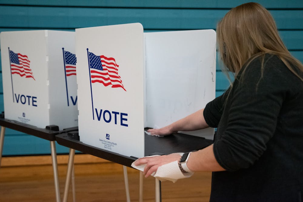 <p>Poll volunteer sanatizing voting stations at Southside Community Center polling location in Lansing Michigan on Tuesday, November 3, 2020. </p>