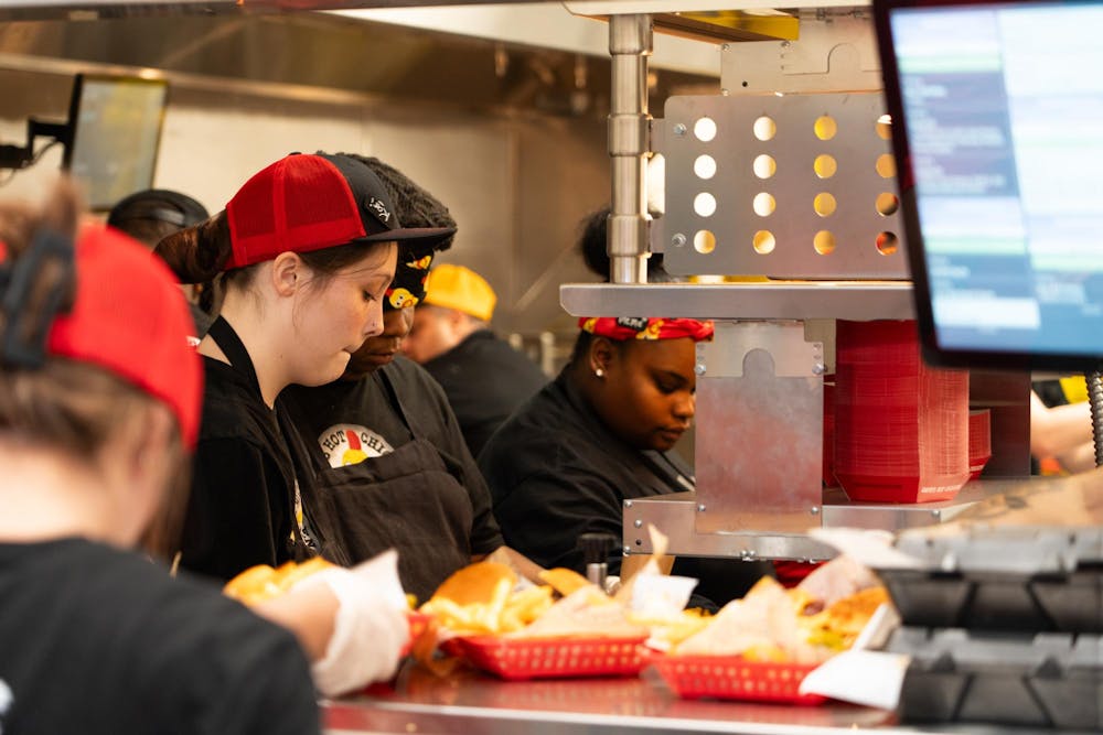 Employees crowd the kitchen at Dave's Hot Kitchen on Friday, Jan. 12 during the restaurant's grand opening. A line of customers waiting to order or pick up food spilled out of the chicken spot's front door.