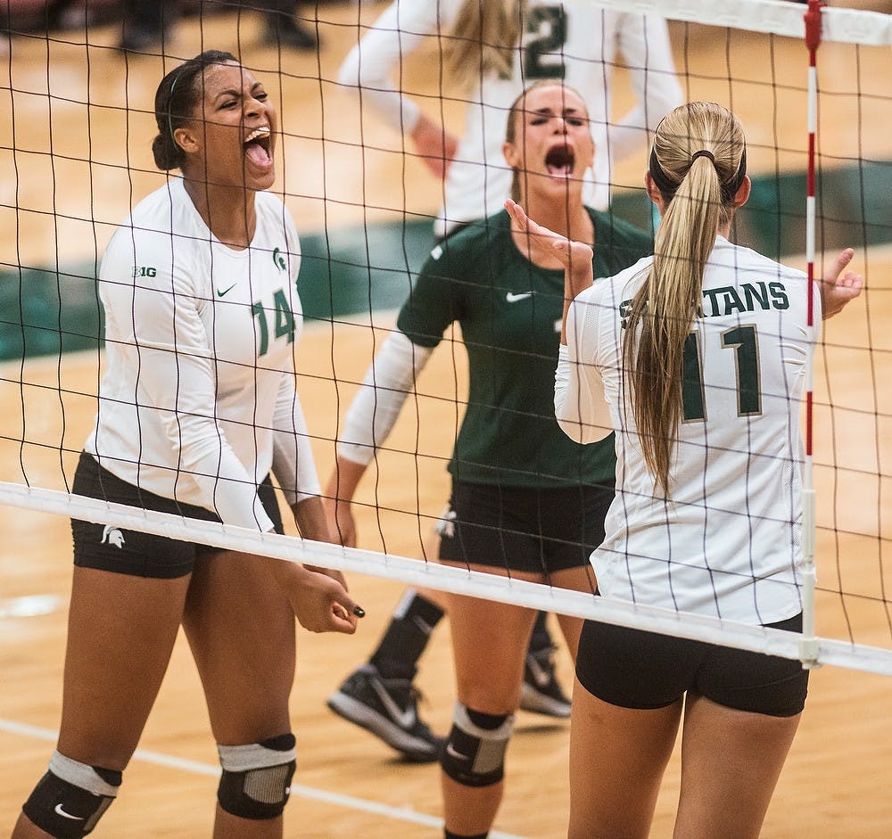 <p>Senior libero Kori Moster cheers with teammates and senior middle blocker Jazmine White and sophomore outside hitter Chloe Reinig after a point Oct. 3, 2014, during a game against the University of Michigan at Jenison Fieldhouse. The Spartans defeated the Wolverines, 3-1. Erin Hampton/The State News</p>