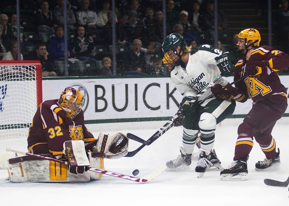 <p>Sophomore forward Villiam Haag skates the puck towards Minnesota goaltender Adam Wilcox on Dec. 6, 2014, at Munn Ice Arena. The Spartans tied the Golden Gophers, 3-3, but won the extra point in a shootout. Danyelle Morrow/The State News</p>