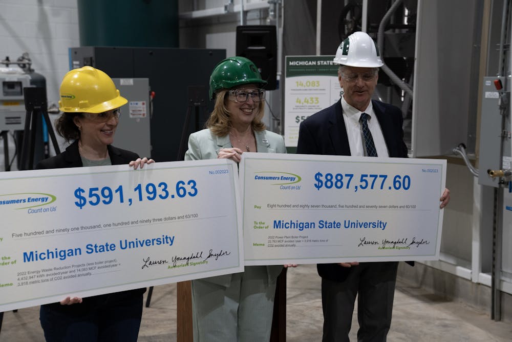 <p>Interim-President Teresa Woodruff holds an oversized check representing the MSU's energy rebates at the Simon Power Plant at a media event on March 20th, 2023.</p>