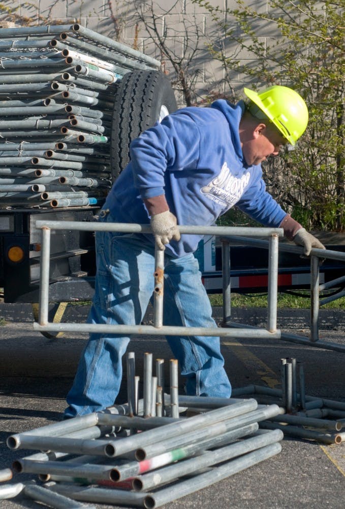 Jose Ramos of Lamar Construction Company prepares the construction site of City Center II Wednesday morning at the corner of Abbott Rd. and Grand River Ave. The predevelopment agreement of City Center II was approved Tuesday night by the East Lansing City Council. Samantha Radecki/The State News