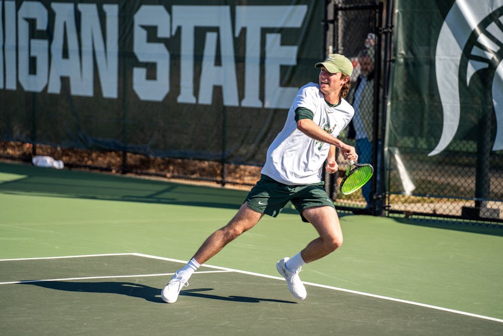 <p>Junior Luke Baylis hitting the ball during the MSU vs. Ohio state match at the MSU Outdoor Tennis Center on April 7, 2023. The Buckeyes defeated the Spartans 7-0.</p>