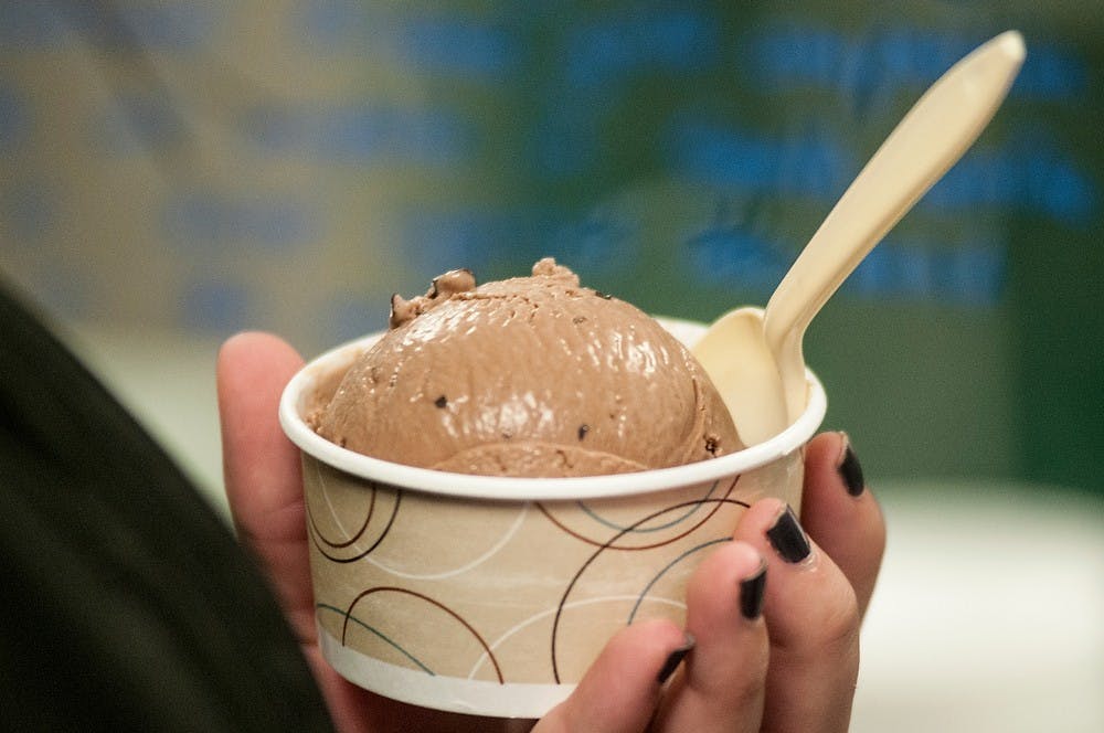 <p>Crop and soil sciences senior Chelsea Koroleski enjoys a small cup of chocolate ice cream Sept. 30, 2014, at the MSU Dairy Store. Raymond Williams/The State News</p>