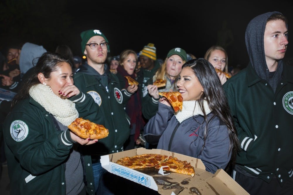 <p>Neuroscience senior Ana Maldonado, left and pre-law and statistics junior Katherine Fernandez eat pizza during Sparty Watch on Oct. 25, 2016 at The Spartan statue. MSU tradition has had head coach Mark Dantonio stop by The Spartan statue with boxes of pizza for the Spartan Marching Band during the week of the MSU vs. University of Michigan football game.</p>
<p><strong>STATE NEWS FILE PHOTO</strong></p>